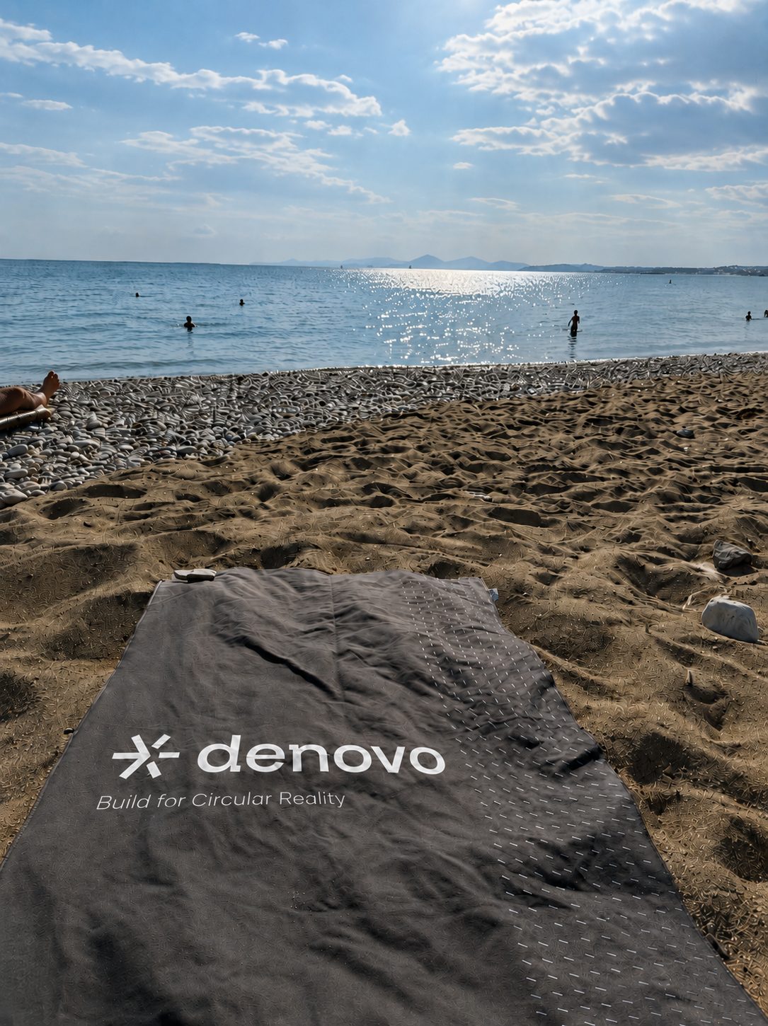 Denovo-Handtuch am Strand während einer Workation